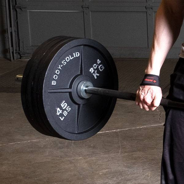 Body-Solid Black Olympic Weight Set - Man Exercising in Garge Gym
