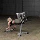 Body-Solid (PLCE165X) Leg Extension/Curl - Woman Performing Lying Leg Curl Exercise