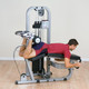 Body-Solid (SLC400G) Commercial Leg Curl Machine - Man Exercising in Workout Room