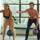 Aeromat Dual-Grip Medicine Balls - Man & Woman Exercising in Fitness Studio