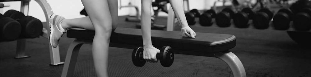 Woman Exercising on Flat Weight Bench in Commercial Gym