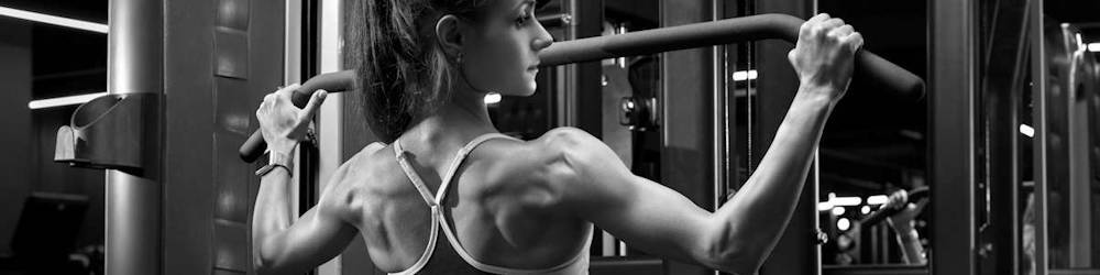 Woman Exercising on Commercial Weight Machine in Gym