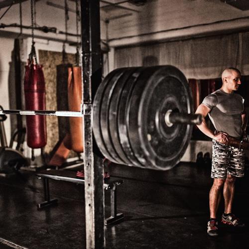 Man Exercising with Fitness Equipment in Military Gym Man Exercising with Fitness Equipment in Military Gym