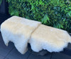 Sheepskin rugs draped over a wooden bench for a more comfortable seating area..