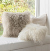 A cosy bay window with a curly Tibetan sheepskin throw pillows.