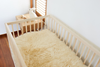 Crib with sheepskin rug lining