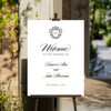 Classic opulent wedding welcome sign clipped to an easel. 