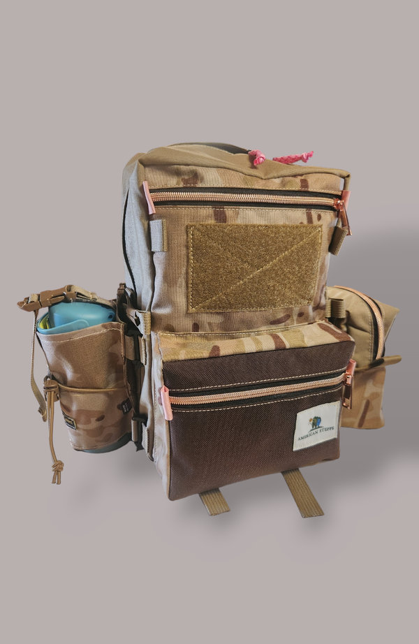 Custom pack with Multicam Arid, Tan, and Dark Brown panels and pink metallic zippers . Also shown with water bottle pouch, side pouch and color logo. Contact us for custom options.