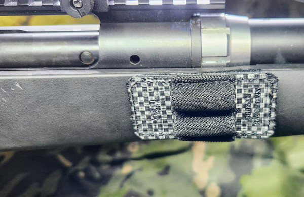 The rifle round holder mounted forward of an action.