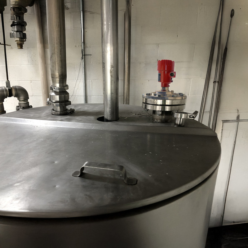 Radar level sensor installed on a food processing tank to measure real-time ingredient levels