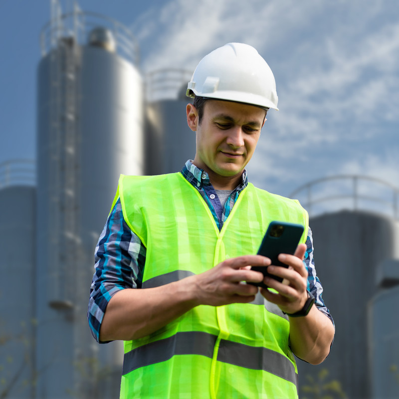 Worker at cement worksite views real-time silo inventory on his phone with BinCloud remote inventory software