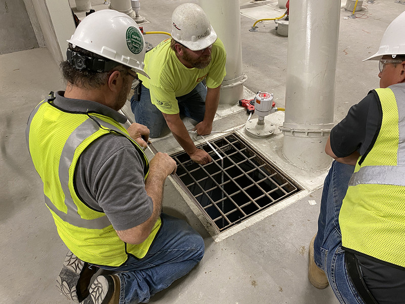 BinMaster workers surround access doors while installing level sensor