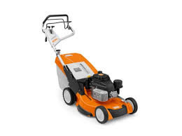 Professional landscaper using Stihl RM 655 YS self-propelled mower on sloped lawn