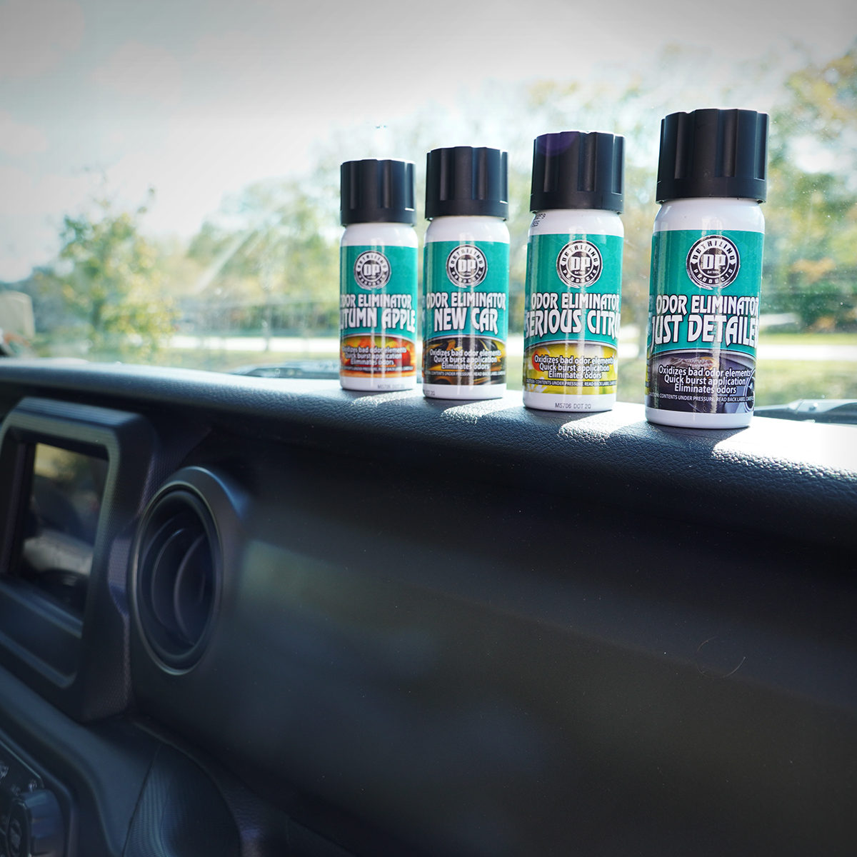 All DP Odor Eliminators sitting on vehicle's dashboard.