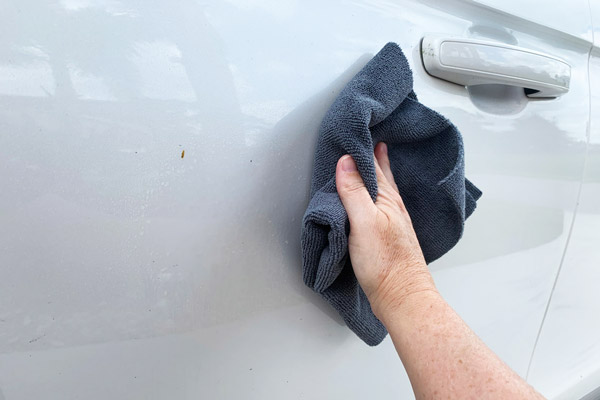 Wiping BLACKFIRE Waterless Wash from the surface to clean car.