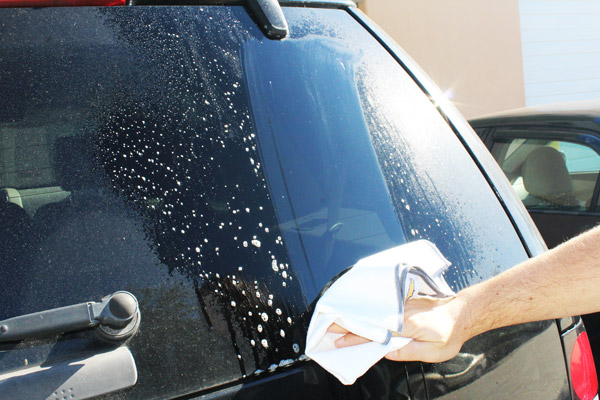 Cleaning dirty glass with Speed Master Premium Glass Towel.