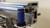 Blue sensor beside the end of the conveyor drive belt system on the J-series PCB conveyor.