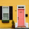 clam door knocker brass on pink door yellow house