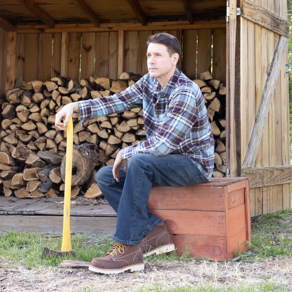 Man sitting on a tree stump posed with an axe wearing men's work boots in style FR40301