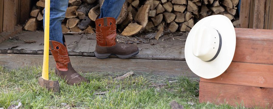 Western style Frye boots worn by person resting after chopping wood