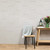Taupe hexagonal effect acoustic wall with decorated table and chair.