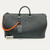 Louis Vuitton Keepall Bandoulière 50 in Absolute Black Monogram Taurillon leather with orange chain strap accents