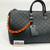 Louis Vuitton Keepall Bandoulière 50 in Absolute Black Monogram Taurillon leather with orange chain strap accents