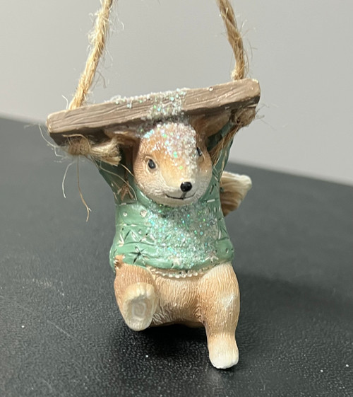 Cute squirrel holding a swing Christmas ornament