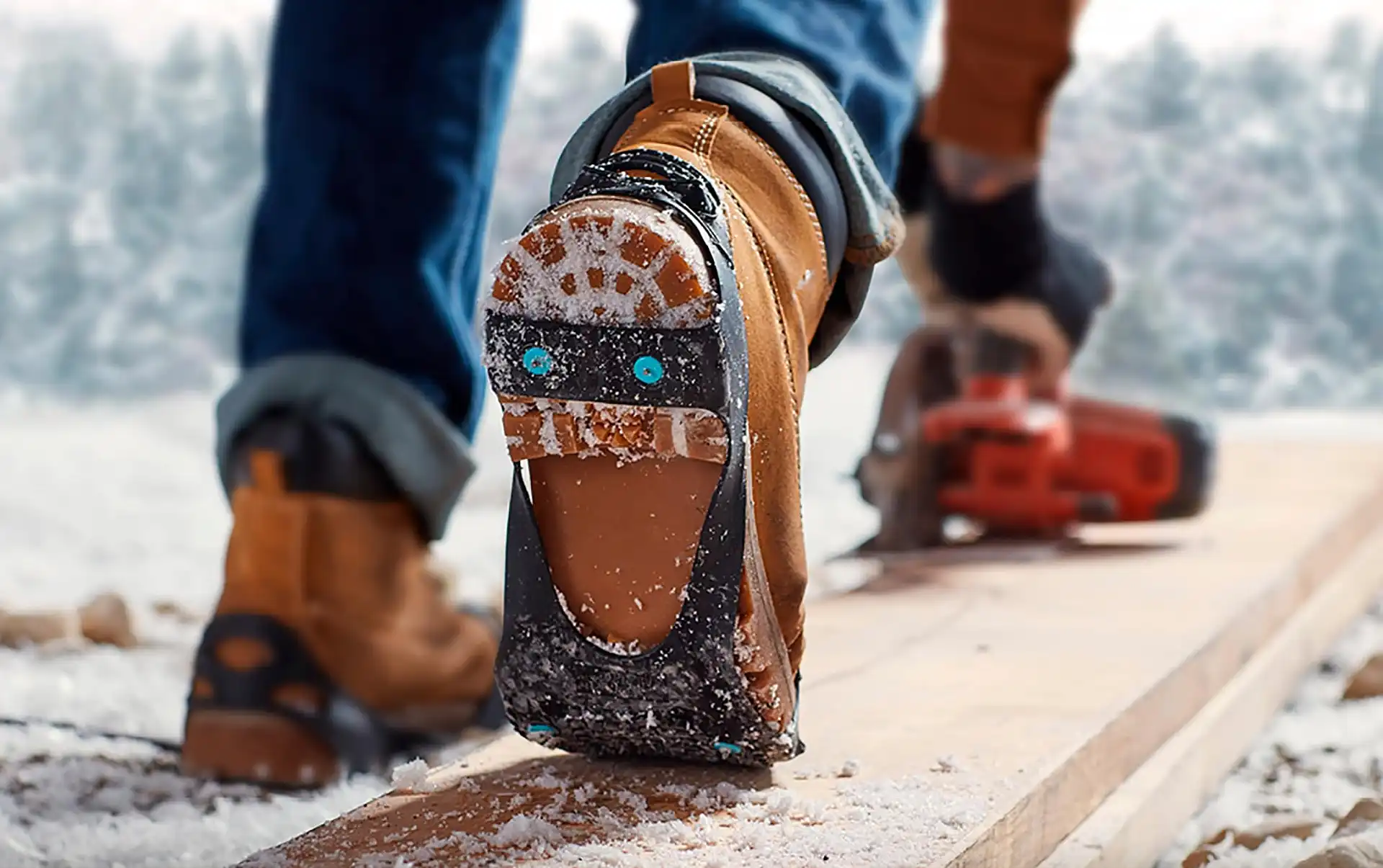 Due North traction aid with carbide spikes strapped over a work boot on a snowy job site