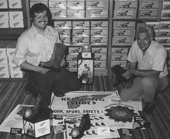 An image of Chet's Shoes founder kneeling in front of a rack of shoe boxes