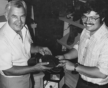 An image of Chet and Chet Jr holding a workboot and showing off the sole of the boot