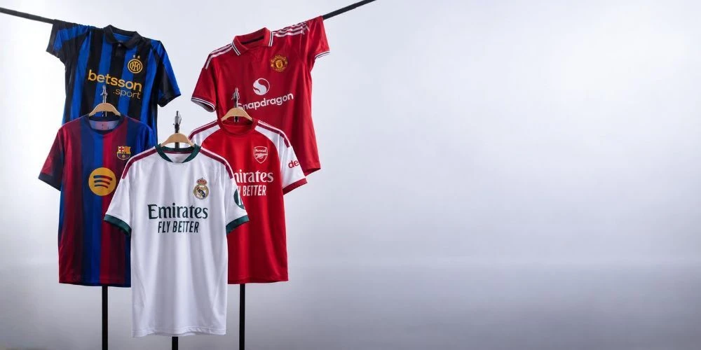 Five football jerseys displayed on hangers