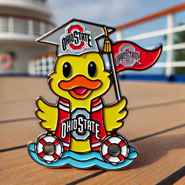 A soft enamel pin featuring a cheerful yellow duck dressed in Ohio State colors (scarlet and gray), wearing a graduation cap with the Ohio State logo and holding a “Go Buckeyes!” pennant. The background includes a cruise ship deck with ocean waves, palm trees, and nautical details.