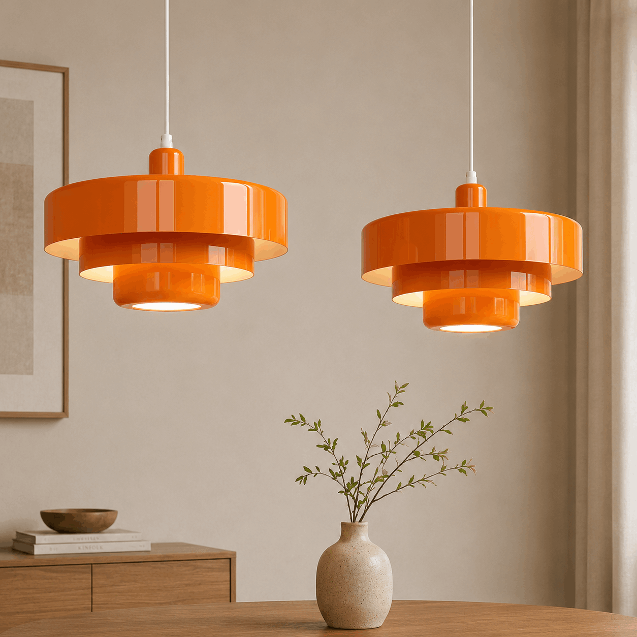 Zwei orange Arven Pendelleuchten mit warmem Licht &uuml;ber einem Esstisch