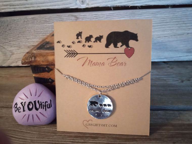 The necklace features a silver round charm, with the words “Mama Bear” and 3 bear cubs in black.