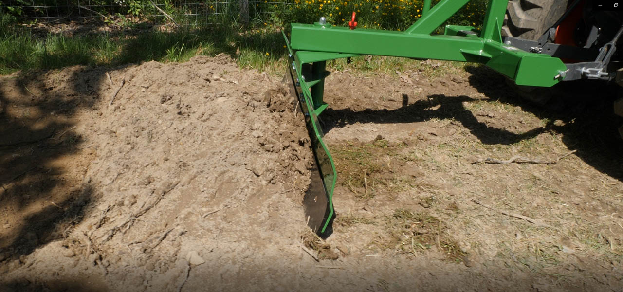 Back Blade in reverse setting pushing dirt pile.