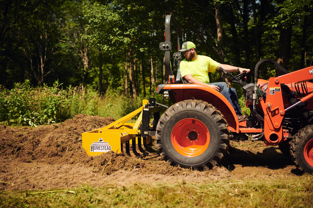 Box Blade spreading large pile of dirt. 