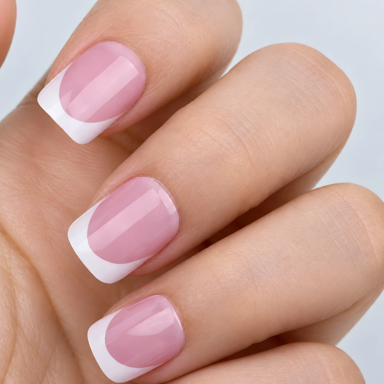 Close-up details of pink bases and white French borders on short square nails