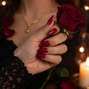 Burgundy red short almond nails worn on a hand