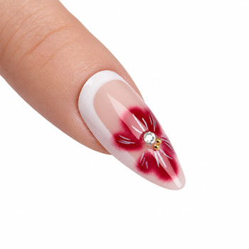 Close-up of red floral nail art and small sparkling accents