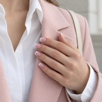 Pink French tip short square nails styled with a neutral outfit