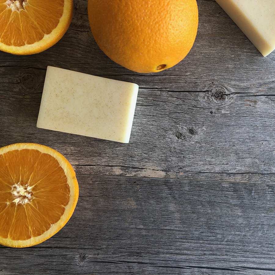 Photo of oranges and orange peel soap on a wooden background