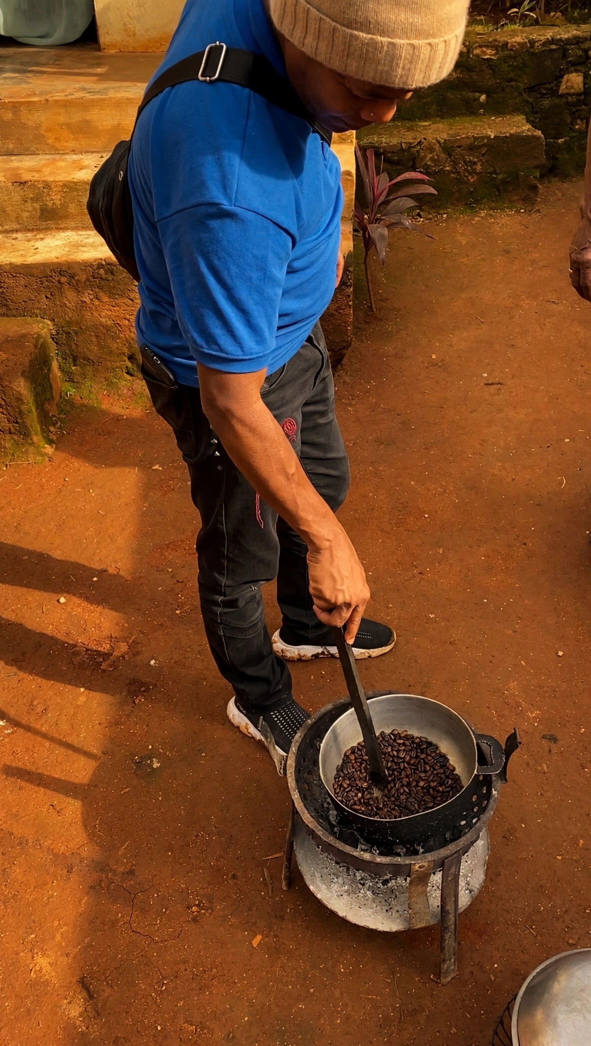 Roaster stirring coffee beans in the pan