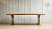 Side profile of the Strand Dining Table, emphasizing its length and robust pedestal legs