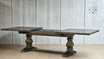 Angled view of the Darcy Oak Table's pedestal base mid-extension, showcasing its support and elegance
