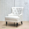 Detailed Front View of Avery Hamptons Armchair: Focused on tufted buttons and beige fabric texture