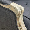 Detailed image of the chair's armrest in black upholstery and oak finish