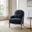 Hamptons-style living room with natural light and an upholstered black occasional armchair styled with a round side table