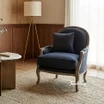 Curved black armchair with weathered oak wood base in a bright, modern interior.