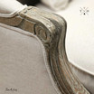 Detailed image of the chair's armrest in linen and oak